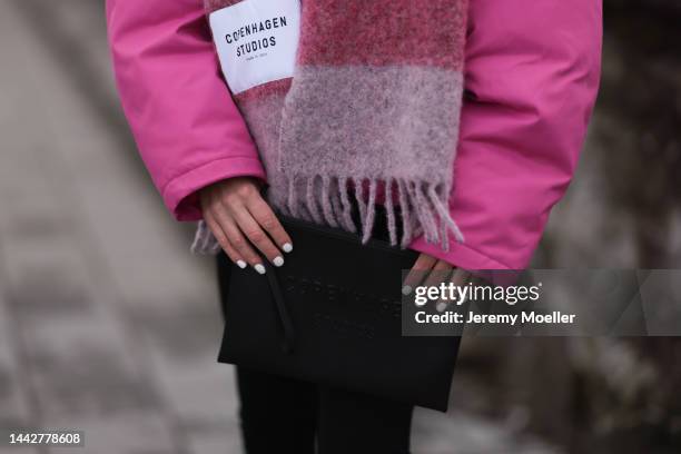 Marie Hindkaer is seen wearing pink checked Copenhagen Studios wool scarf, Copenhagen Studios clutch, pink H&M studio jacket and black Toteme...