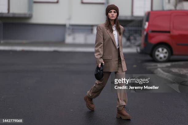 Liberta Haxhikadriu is seen wearing Copenhagen Studios CPH149 recycled nylon nut brown boots, Bottega Veneta mini Jodie black leather bag, Munthe...