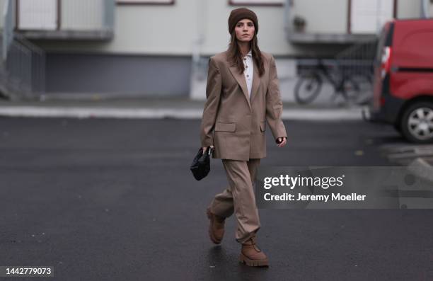 Liberta Haxhikadriu is seen wearing Copenhagen Studios CPH149 recycled nylon nut brown boots, Bottega Veneta mini Jodie black leather bag, Munthe...