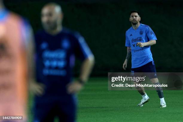 Lionel Messi of Argentina trains away from the main squad with the medical adviser during the training session for Team Argentina at Qatar University...