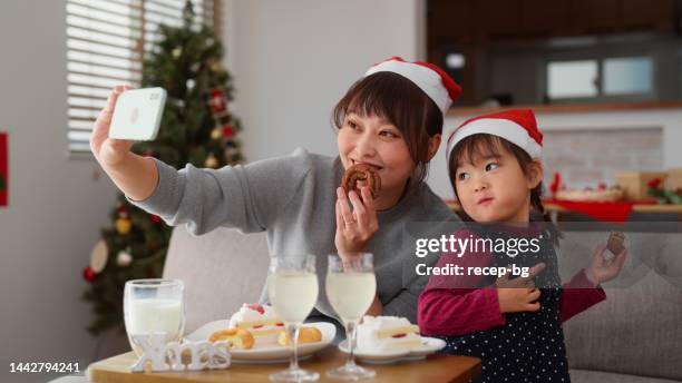 mother and her small preschool age daughter  enjoying christmas at home - christmas cake stock pictures, royalty-free photos & images