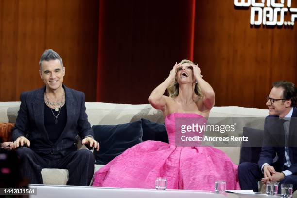 Robbie Williams , Michelle Hunziker and Michael Herbig speak on stage during the "Wetten, dass...?" Live Show on November 19, 2022 in...