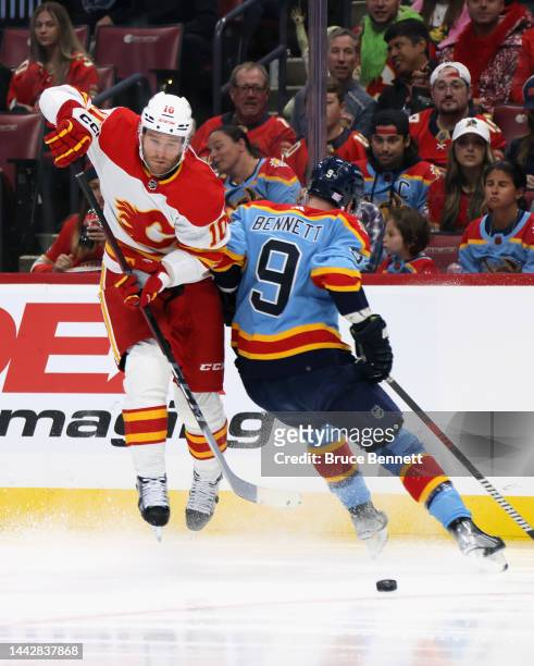 Jonathan Huberdeau of the Calgary Flames jumps to get past Sam Bennett of the Florida Panthers during the first period at FLA Live Arena on November...