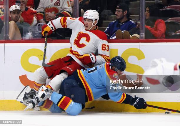 Adam Ruzicka of the Calgary Flames is checked by Radko Gudas of the Florida Panthers during the first period at FLA Live Arena on November 19, 2022...