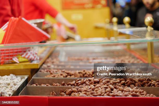 heap of roasted almond on the stall at christmas market. - almond stock pictures, royalty-free photos & images