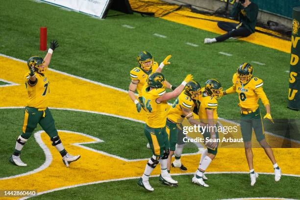 Cam Miller of the North Dakota State Bison celebrates his fifth touchdown with teammates in the second half against the North Dakota Fighting Hawks...