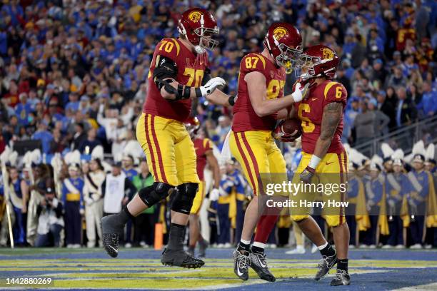 Austin Jones of the USC Trojans celebrates with Lake McRee and Bobby Haskins after scoring a touchdown against the UCLA Bruins during the second...