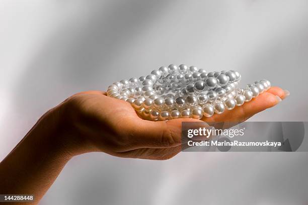 woman's hand holding costume pearls - pearl necklace stock pictures, royalty-free photos & images