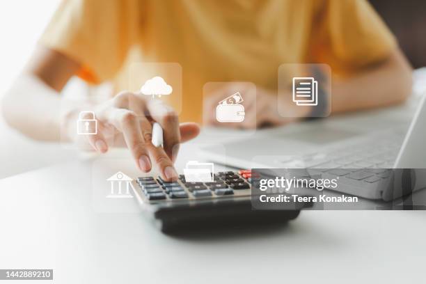 woman using calculator to calculate her income and expenses at home. - busta paga foto e immagini stock