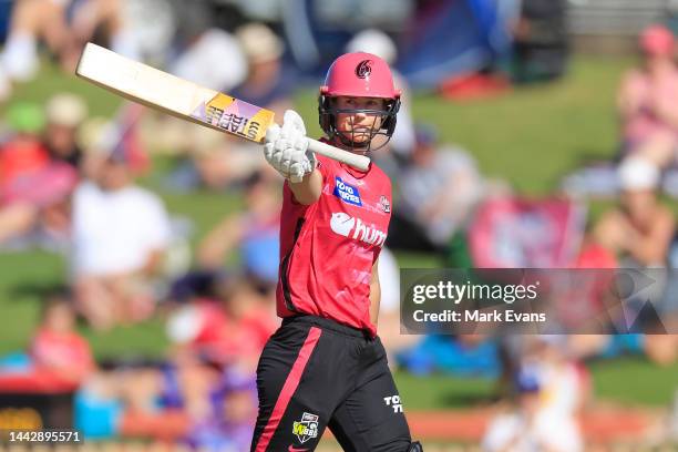 Ellyse Perry of the Sixers raises her bat to the crowd as she reaches her half century during the Women's Big Bash League match between the Sydney...