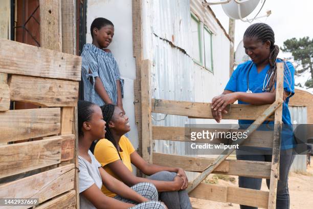 community nurse talking happliy to teenage girls in an informal settlement - african village bildbanksfoton och bilder