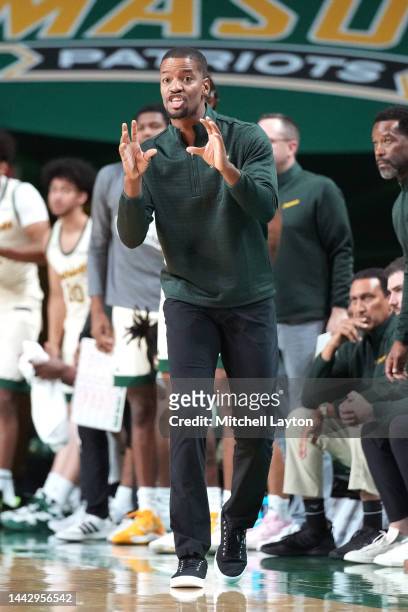 Head coach Kim English of the George Mason Patriots signals to his players during a college basketball game against the American University Eagles at...