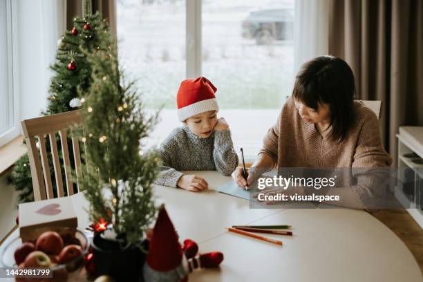 mother and son writing a letter to santa clause - sending stock pictures, royalty-free photos & images