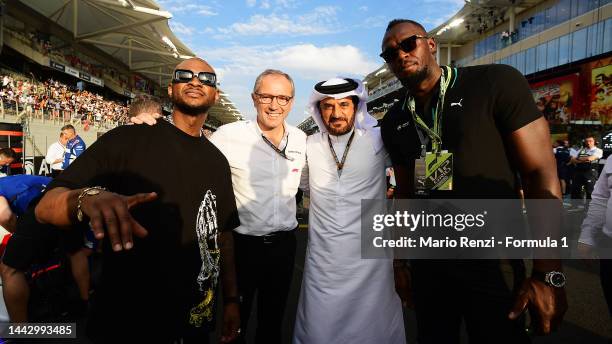 Usain Bolt, Usher, Mohammed ben Sulayem, FIA President and Stefano Domenicali, CEO of the Formula One Group pose for a photo on the grid prior to the...