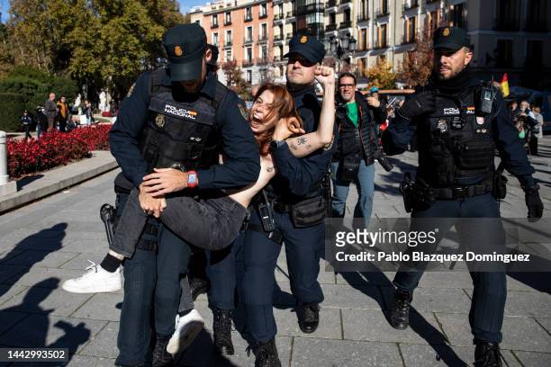 Police restrain a FEMEN activist with body paint during a counterprotest before the start of a rally commemorating the 47th anniversary of Spain's...