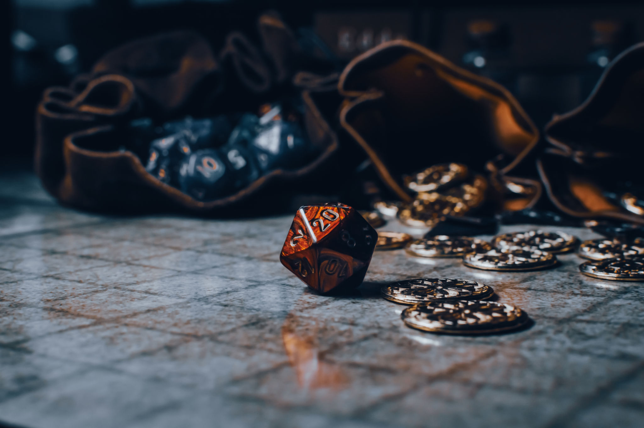 Red RPG die on a gaming grid with game coins and dice bags Red RPG die on a gaming grid with game coins and dice bags