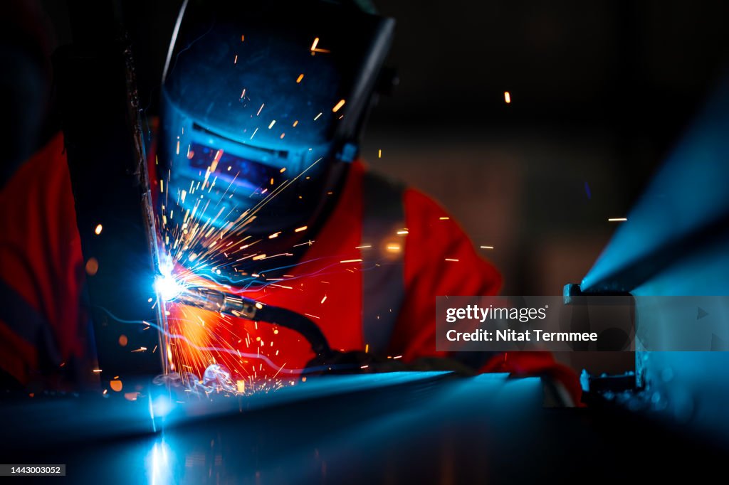 Structural Welding, Welding Engineering. African American welders use carbon arc welding torches for spot welding of a construction beam in the construction industry.