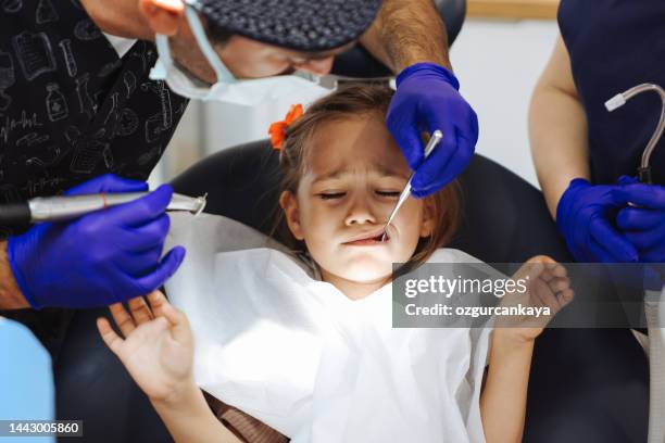 niña pequeña echa un vistazo a los dientes en la oficina del dentista - dental fear fotografías e imágenes de stock