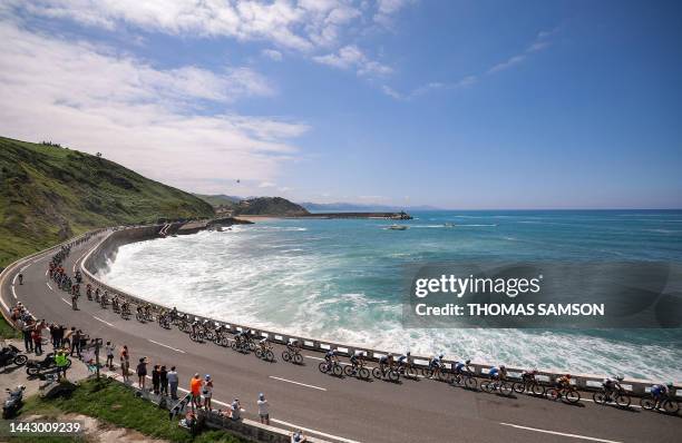 The pack of riders cycles along the Bay of Biscay coastline, near Getaria, in the Basque region of Northern Spain, during the 3rd stage of the 110th...