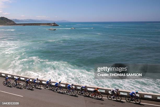 The pack of riders cycles along the Bay of Biscay coastline, near Getaria, in the Basque region of Northern Spain, during the 3rd stage of the 110th...