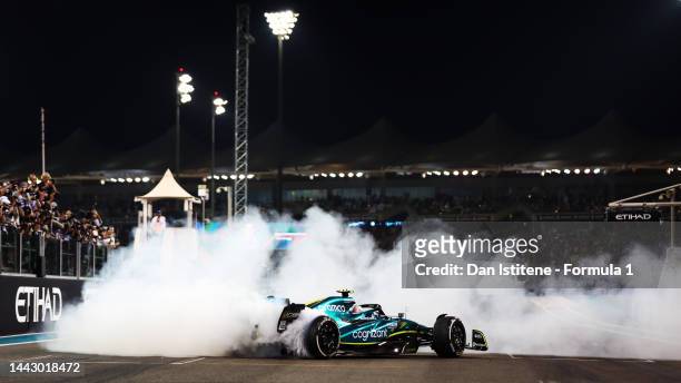 Tenth placed Sebastian Vettel of Germany driving the Aston Martin AMR22 Mercedes performs donuts at the end of his final race during the F1 Grand...