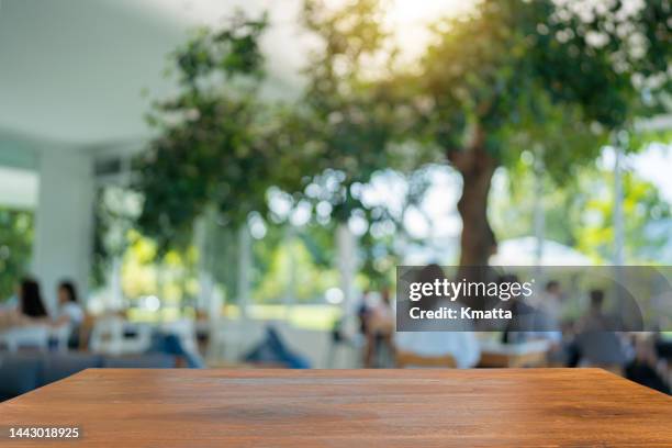 wood table top on blurred of cafe shop with people background. - business unscharf stock-fotos und bilder