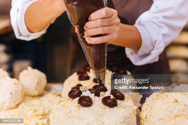 woman making chocolate cake at the bakery, close-up - chocolate cake stock pictures, royalty-free photos & images