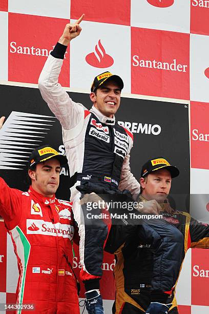 Race winner Pastor Maldonado of Venezuela and Williams celebrates on the shoulders of second placed Fernando Alonso of Spain and Ferrari and third...