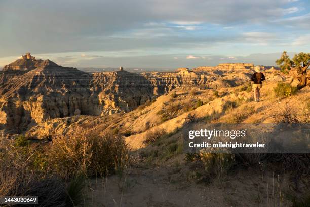 mulher aproveita pôr do sol sobre área nacional de recreação angel peak novo méxico badlands - badlands - fotografias e filmes do acervo