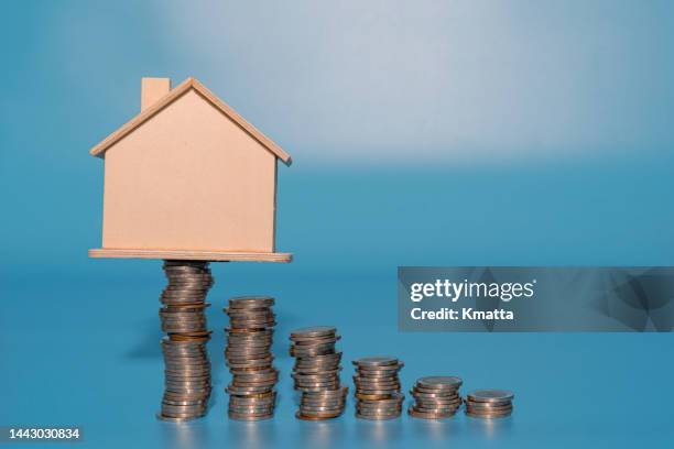 house model on top of coins stacks. save and investment money concept. - welvaart stockfoto's en -beelden