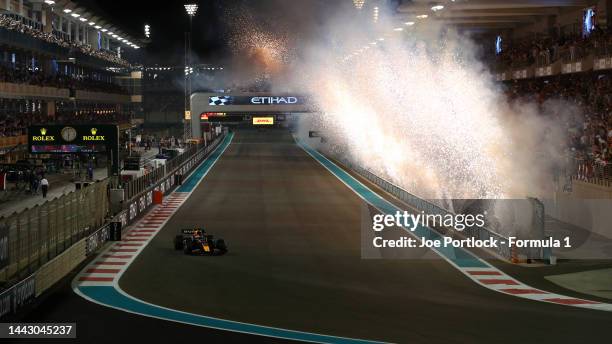 Race winner Max Verstappen of the Netherlands driving the Oracle Red Bull Racing RB18 crosses the finish line as fireworks are seen during the F1...