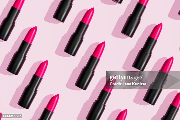 pink lipsticks, lip gloss on trendy pastel background. cosmetic products. makeup accessories. skin care. beauty 3d pattern. - pintalabios fotografías e imágenes de stock