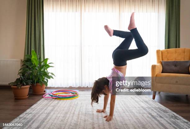 little girl doing gymnastics at home - girls in leggings stockfoto's en -beelden