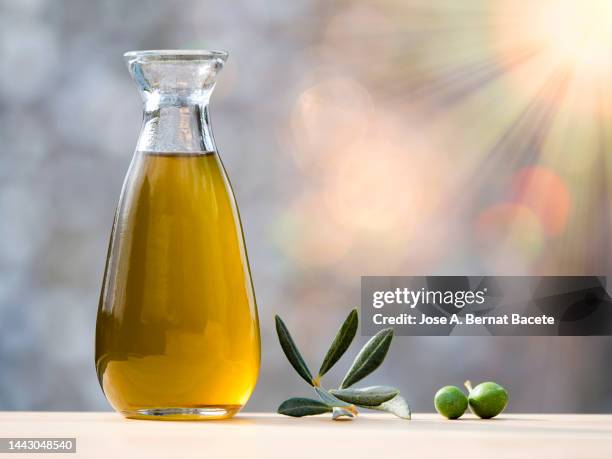 bottle of olive oil and ripe olive illuminated by sunlight. - aliño para la ensalada fotografías e imágenes de stock