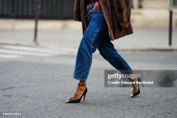Emilie Joseph wears a red and burgundy print pattern silk turtleneck blouse / shirt from Saint Laurent, a brown fur vintage coat, blue denim double...