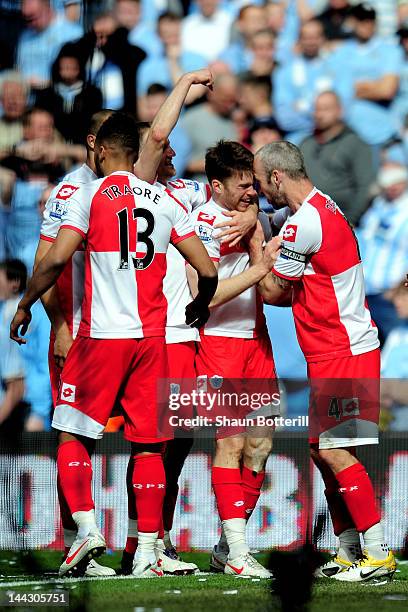 Jamie Mackie of QPR is congratulated by teammate Shaun Derry after scoring his team's second goal during the Barclays Premier League match between...