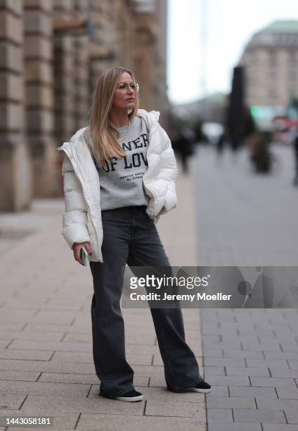 Julia Conrad seen wearing a white Julove jacket and grey sweater, black Adidas sneaker, grey Zara jeans and black Chanel bag on November 18, 2022 in...