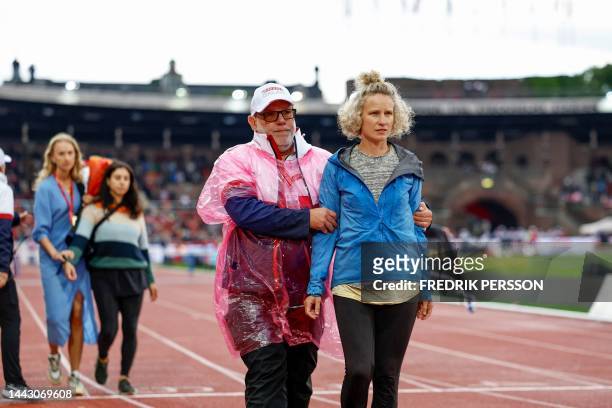 An environmental activist is led off the race track after disrupting the men's 400m hurdles with an environmental protest during the Diamond League...