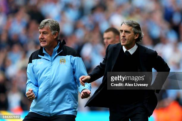 Assistant coach Brian Kidd and Roberto Mancini the manager of Manchester City react during the Barclays Premier League match between Manchester City...