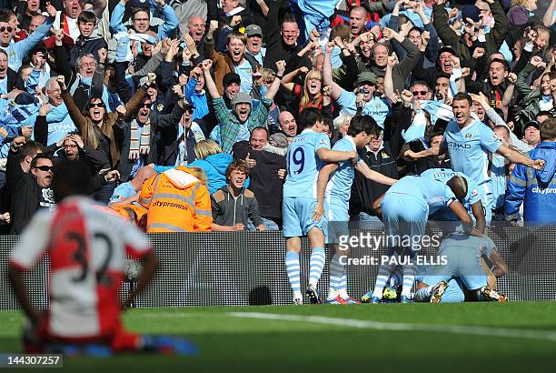 Manchester City's Argentinian striker Sergio Aguero celebrates his late winning goal with team-mates during the English Premier League football match...