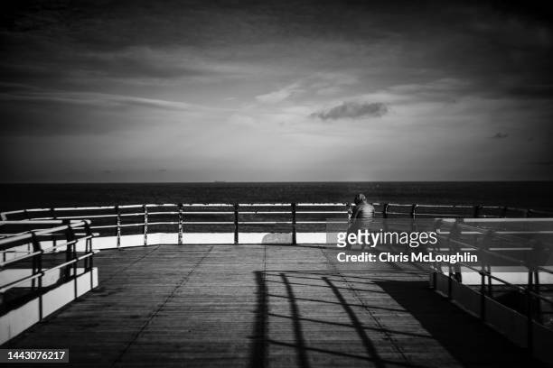 lone person on the pier at saltburn by the sea in teeside - saltburn stock pictures, royalty-free photos & images
