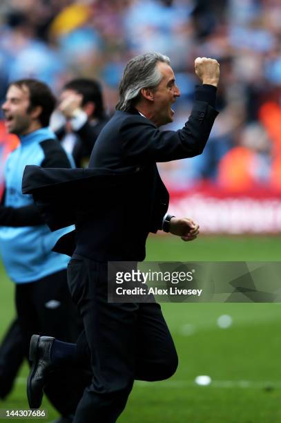 Roberto Mancini the manager of Manchester City celebrates winning the title as the final whistle blows during the Barclays Premier League match...
