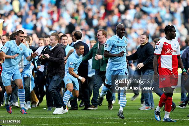 Mario Balotelli of Manchester City and teamates celebrate winning the title with fans after the final whistle blows during the Barclays Premier...