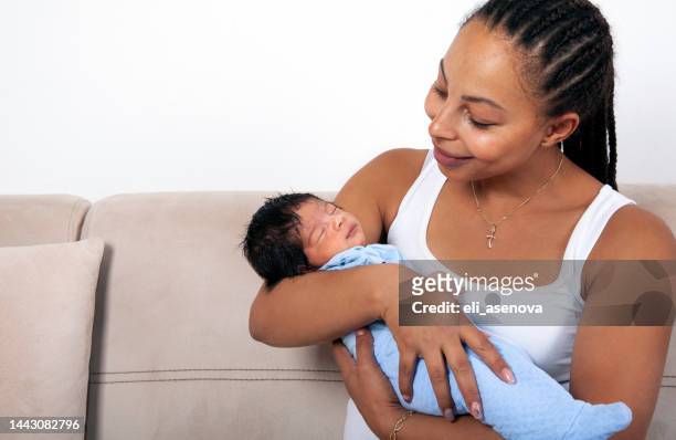 beautiful african american mother holds newborn baby in the living room - adult diaper stockfoto's en -beelden