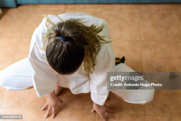 blonde girl in a mask practicing karate at home. karate black belt. quarantine virus. home isolated. - karate girl isolated stock pictures, royalty-free photos & images