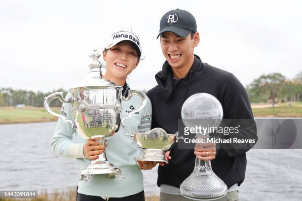 Lydia Ko of New Zealand poses for a photo with her fiancé, the Vare Trophy, the Rolex Player of the Year trophy and the CME Globe trophy after...