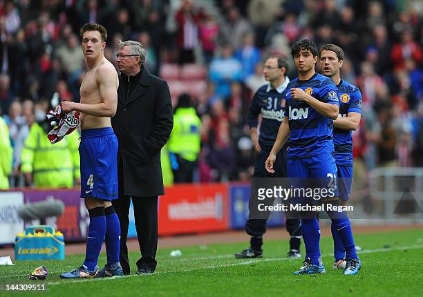 Phil Jones, Sir Alex Ferguson, Rafael Da Silva and Michael Owen of Manchester United look dejected as the crowd react to the winning goal at...