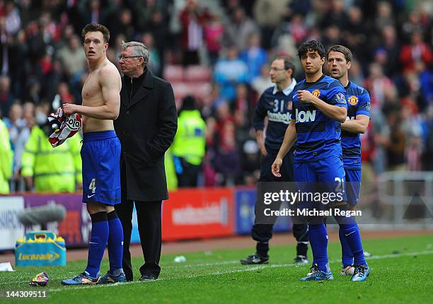 Phil Jones, Sir Alex Ferguson, Rafael Da Silva and Michael Owen of Manchester United look dejected as the crowd react to the winning goal at...