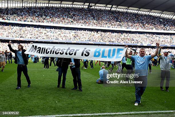 Manchester City fans celebrate after their team wins the title during the Barclays Premier League match between Manchester City and Queens Park...