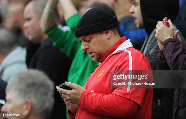 Manchester United fan checks his phone during the Barclays Premier League match between Sunderland and Manchester United at the Stadium of Light on...